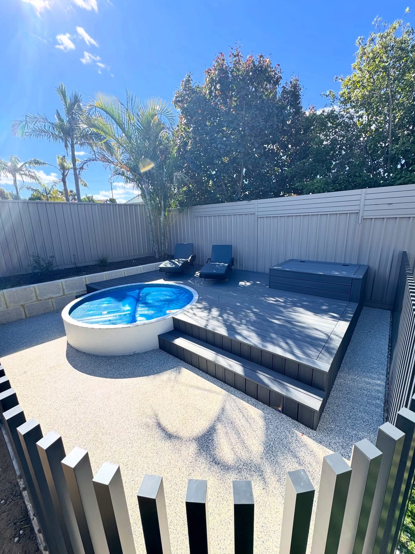 Resin bound surround around a circular plunge pool and raised timber deck