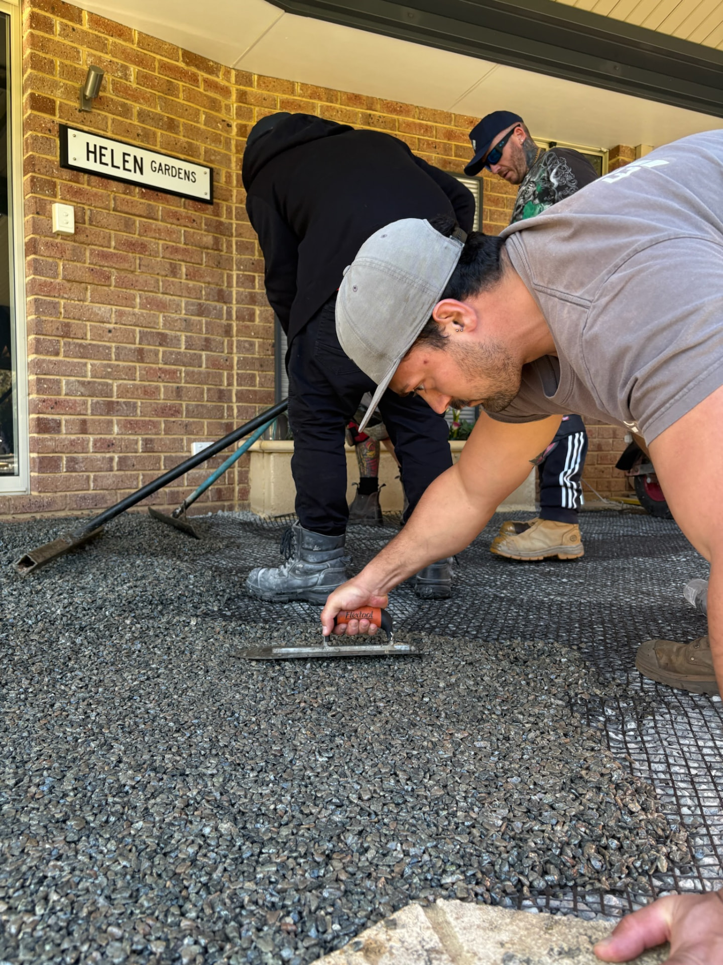 Trainee hand-finishing resin bound surface with Flextool trowel