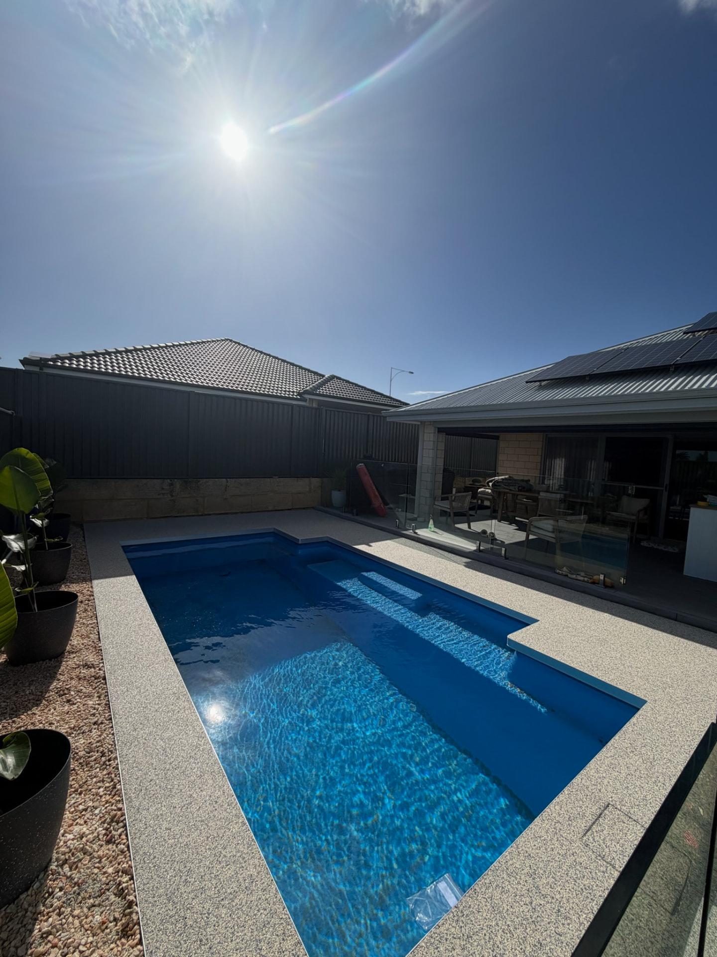 Resin bound pool surround Perth with glass pool fence and patio