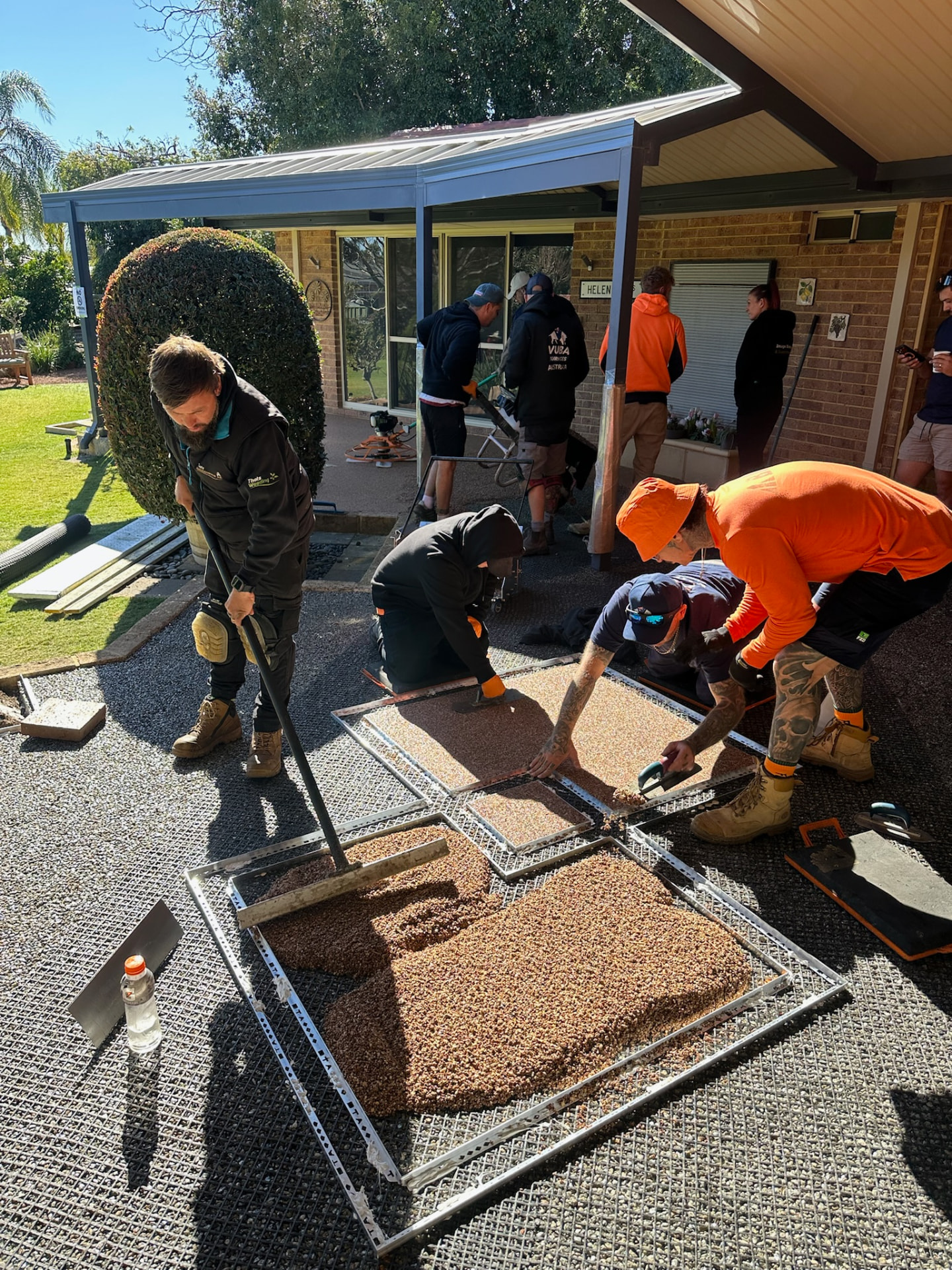 Trainees screeding resin bound aggregate into forms