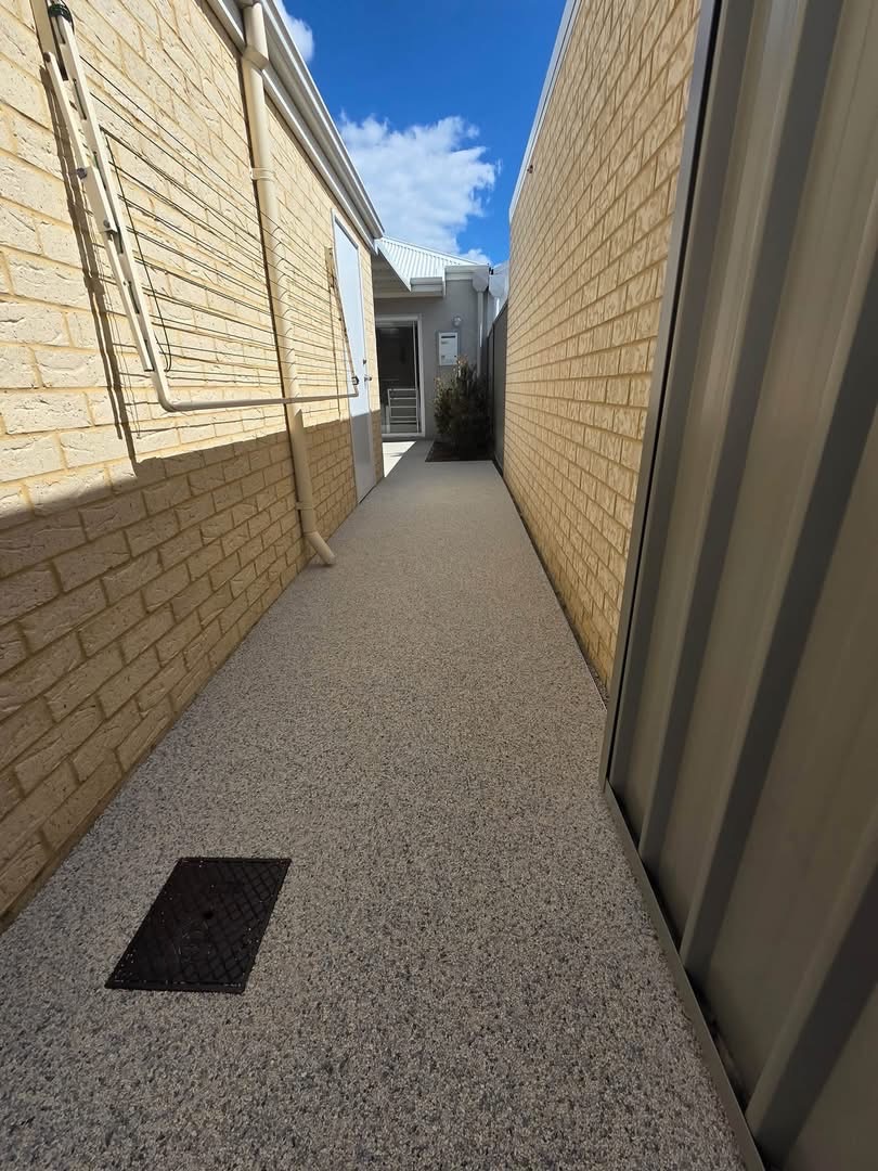 Resin bound side pathway between brick walls with flush drain cover