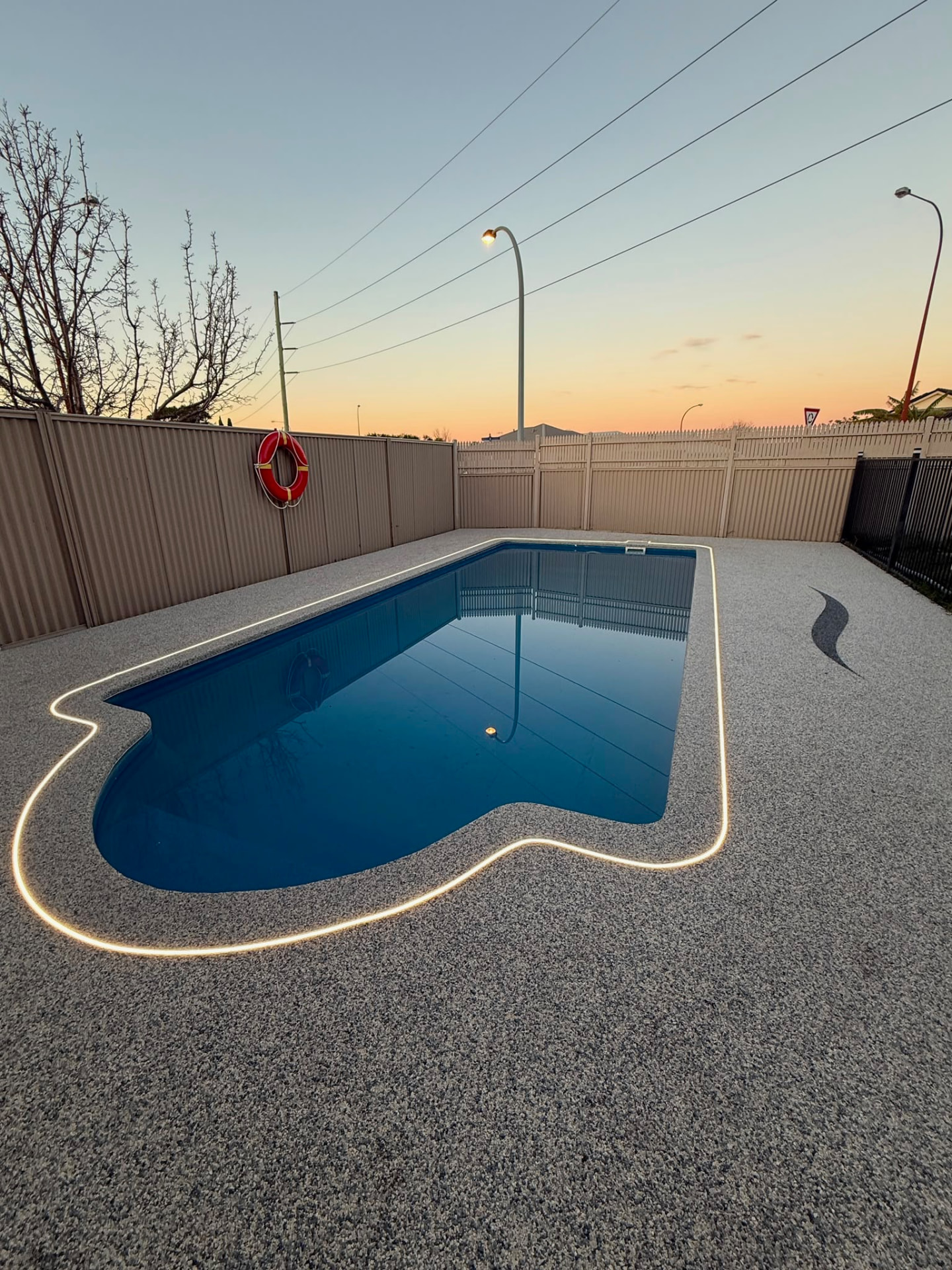 Resin bound pool surround Perth at sunset with LED strip lighting