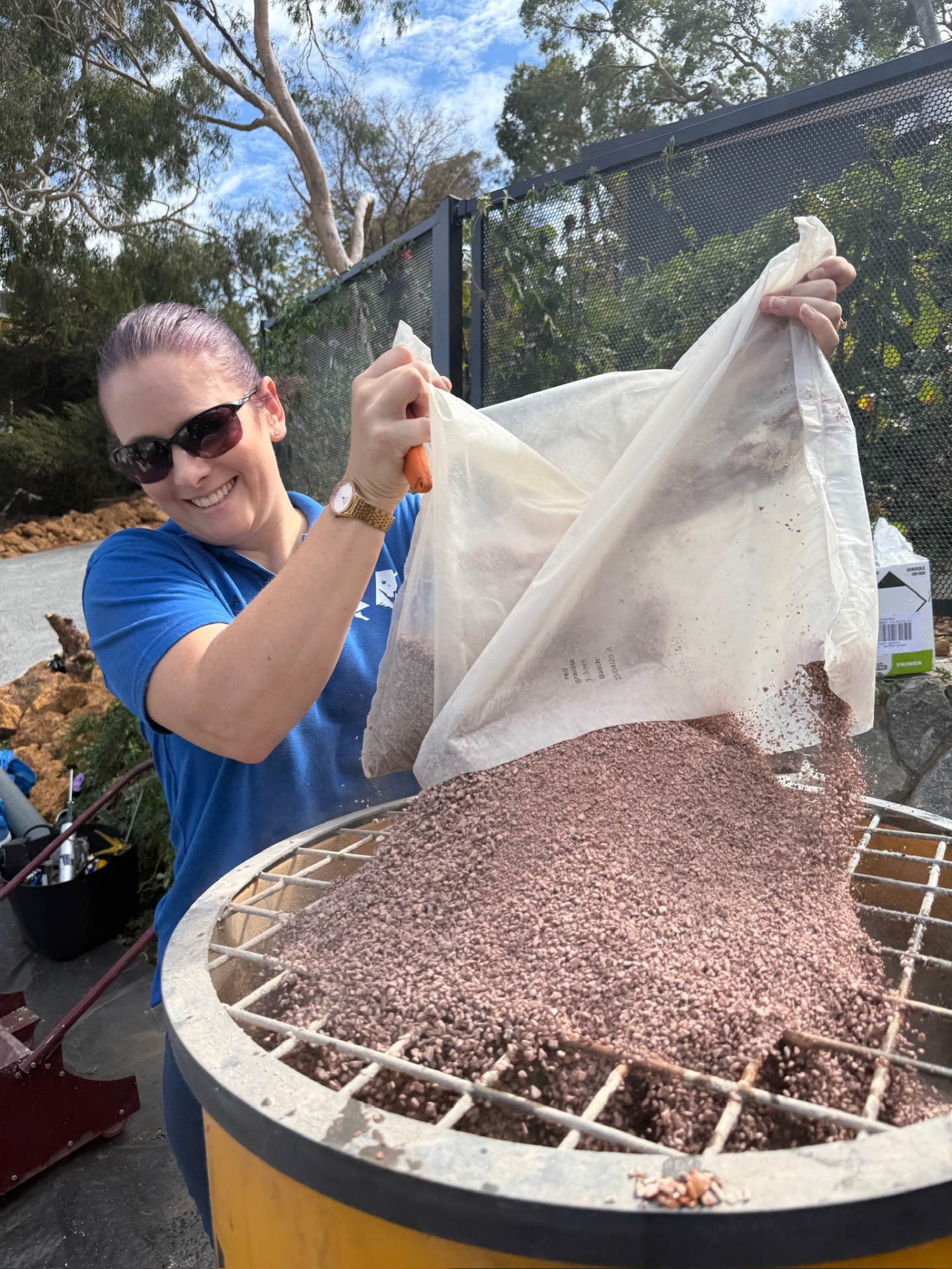 Trainee pouring aggregate into mixer
