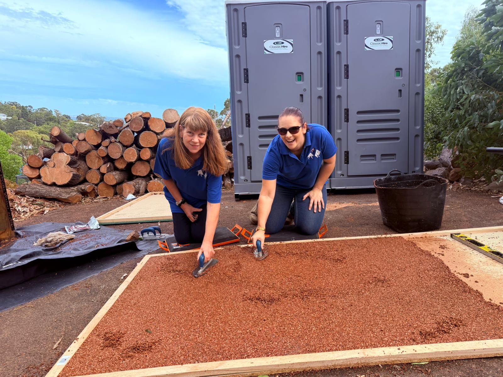 Two trainees practising trowelling technique