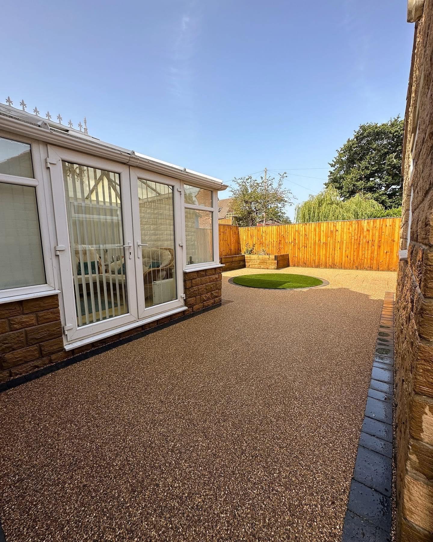 Resin bound backyard patio with wooden fence