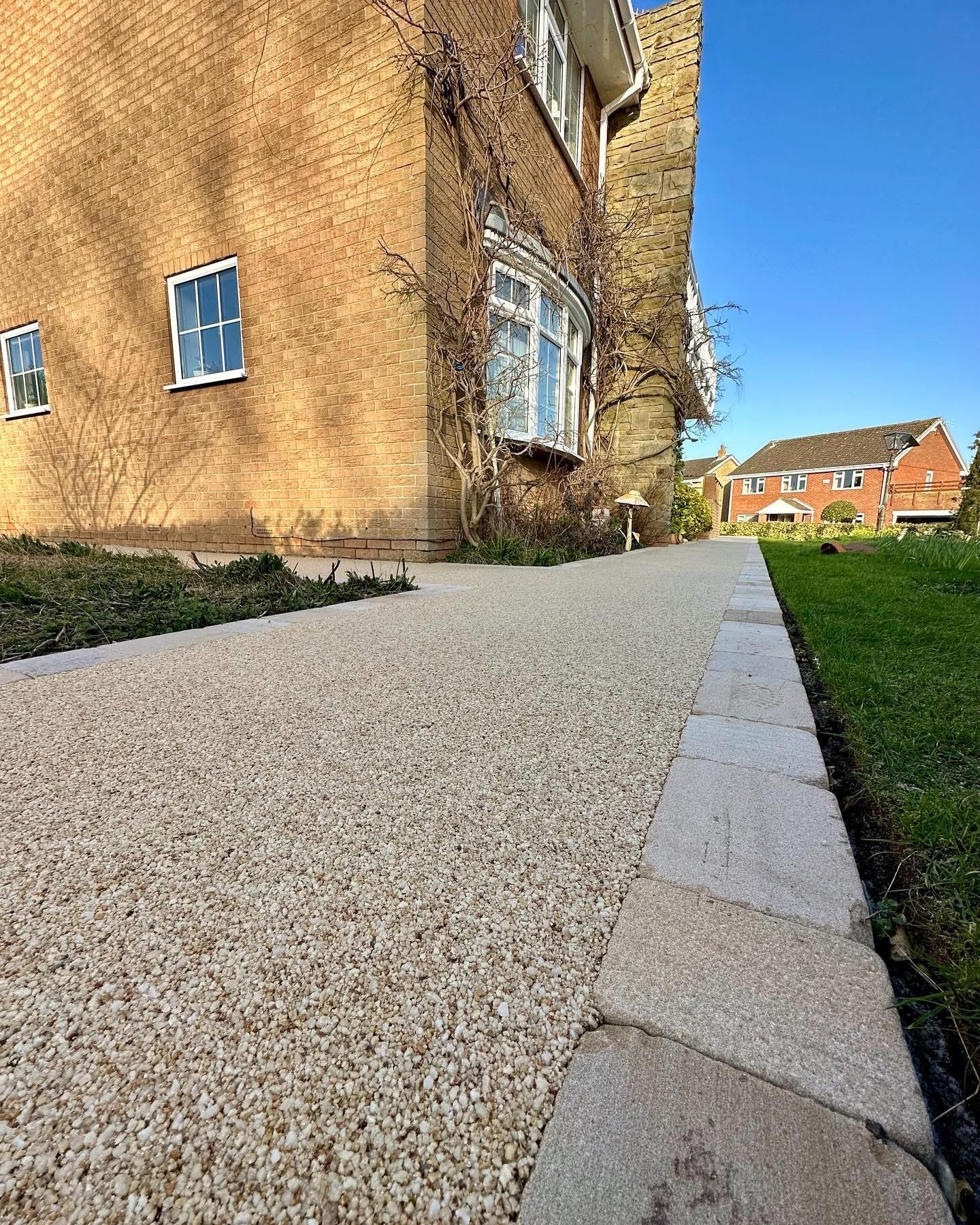 Light resin bound pathway next to brick house