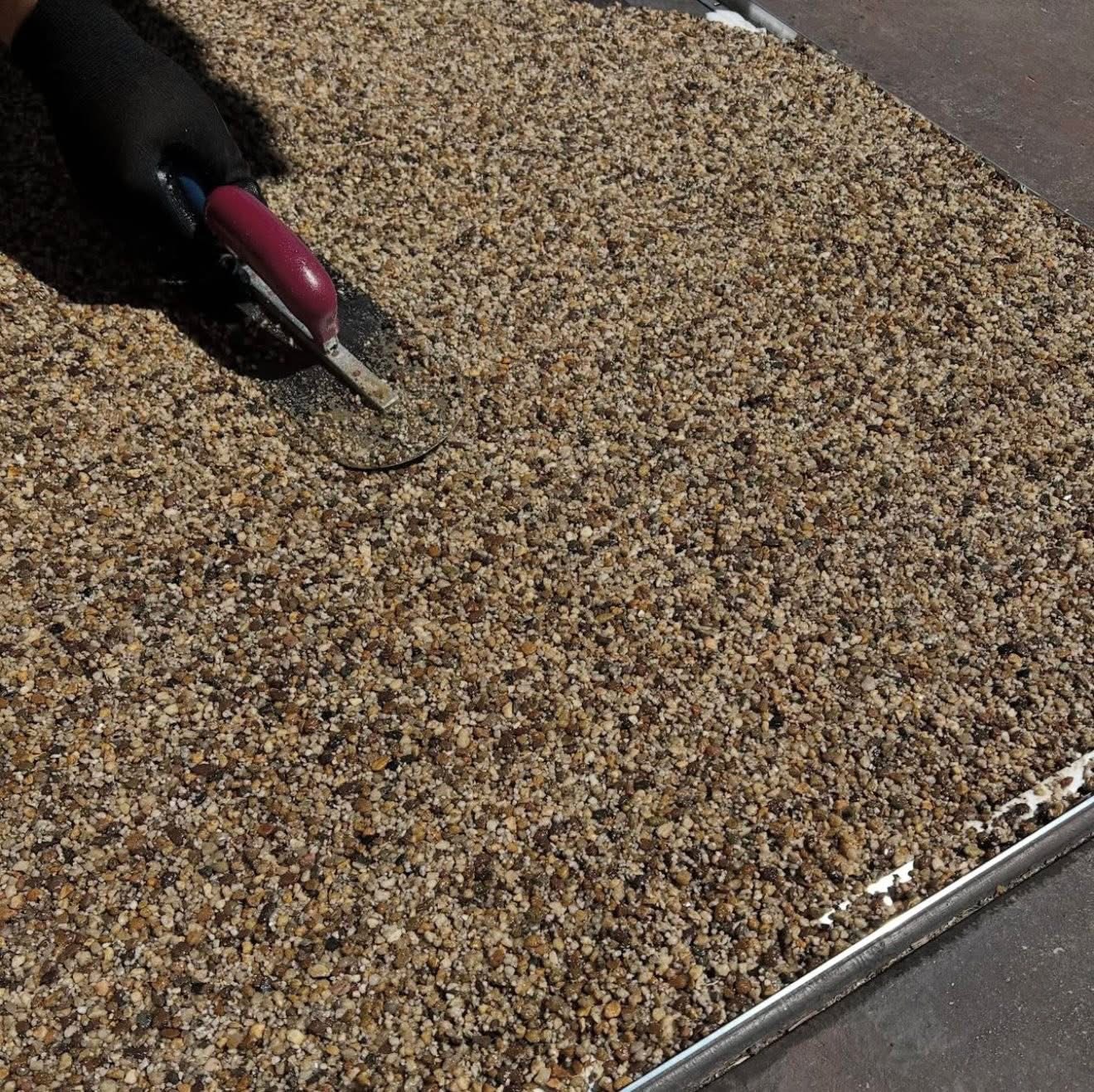 Close-up of hand trowelling resin bound stone