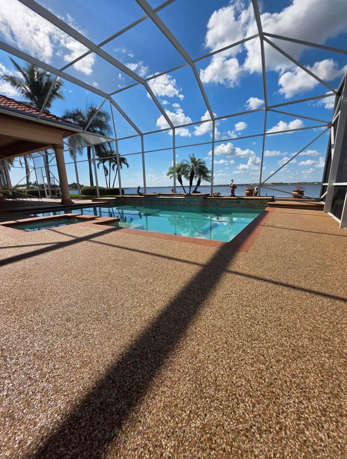 Resin bound pool surround with screened enclosure and waterfront view