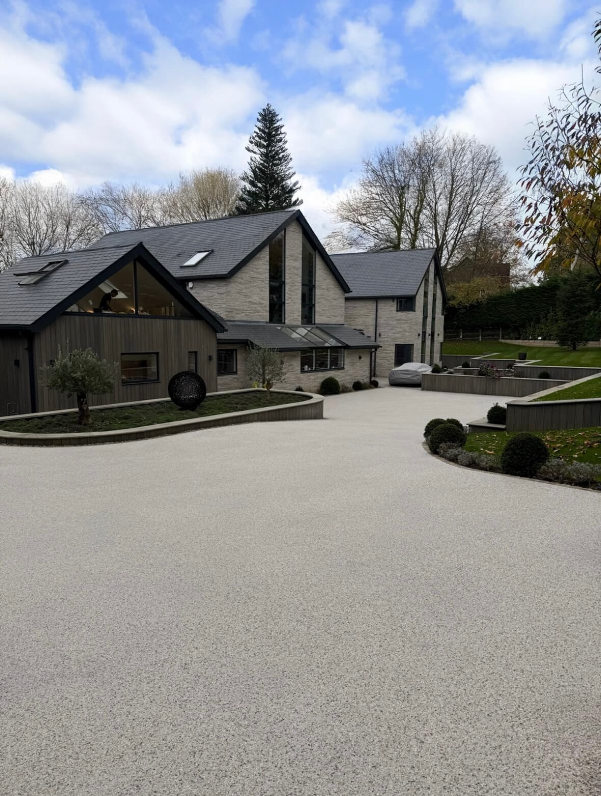 Resin bound driveway with modern architectural home and landscaped gardens