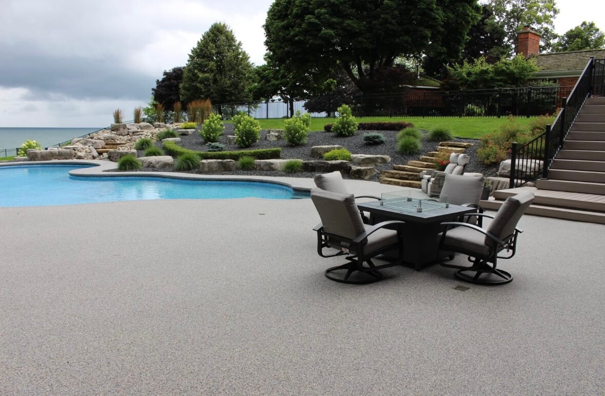 Resin bound pool patio with outdoor dining and lakefront landscaping