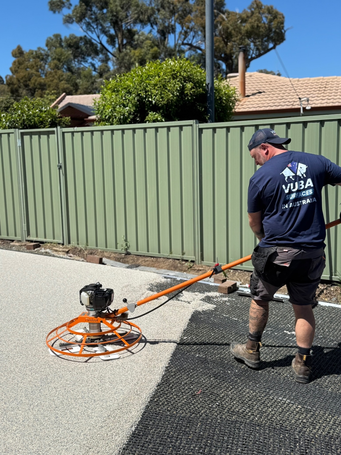 Vuba installer using power trowel on driveway