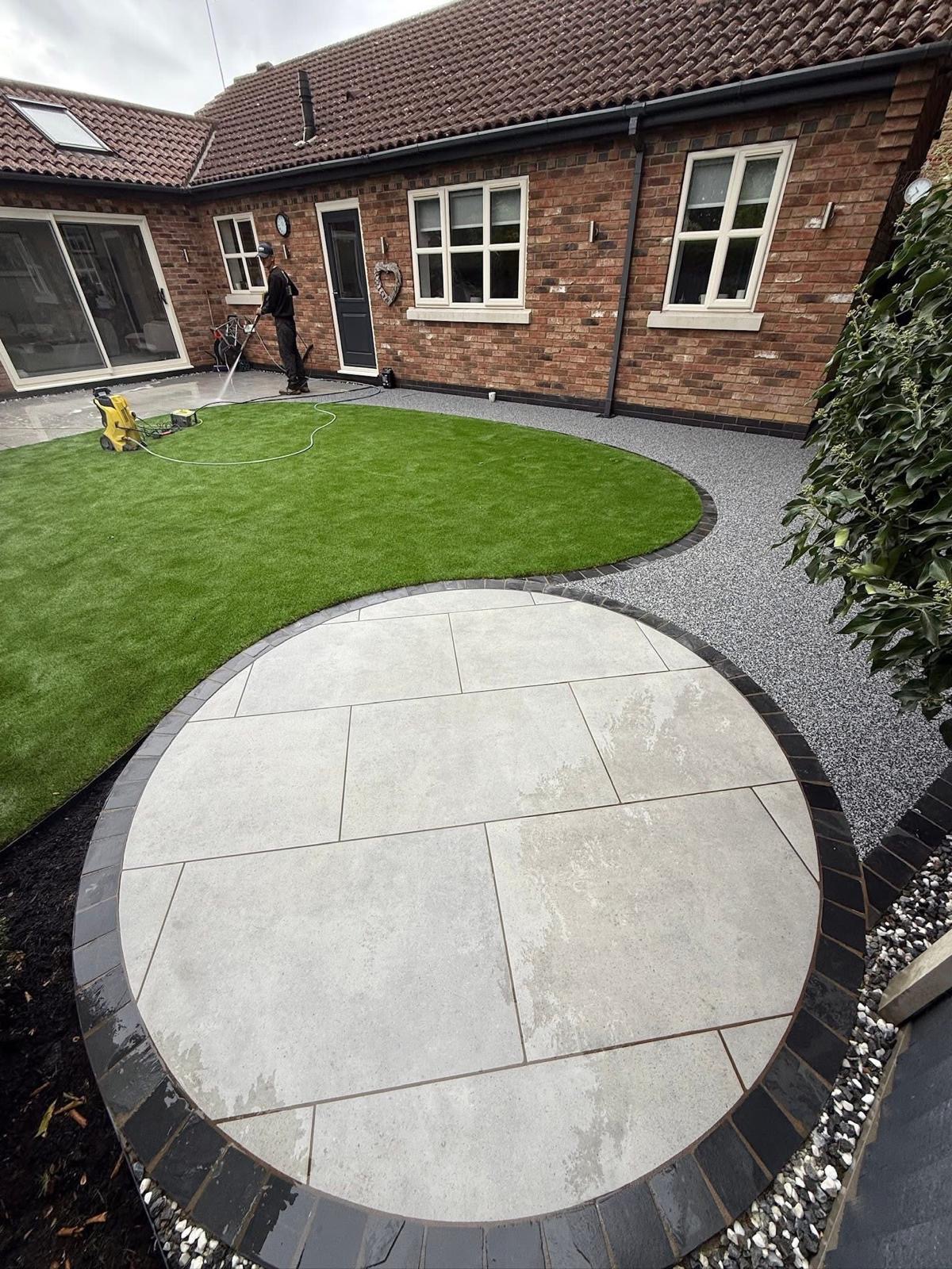 Resin bound patio with circular paving and artificial grass