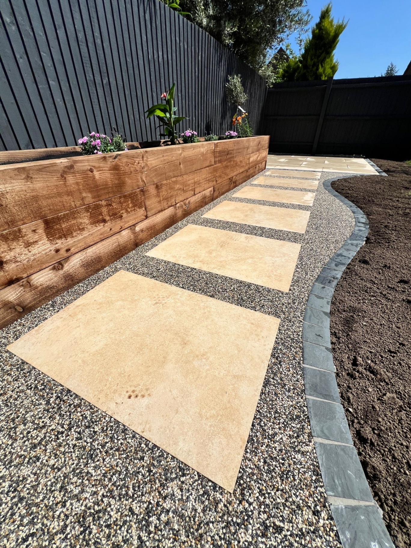 Resin bound stepping stone pathway with wooden raised bed and flowers