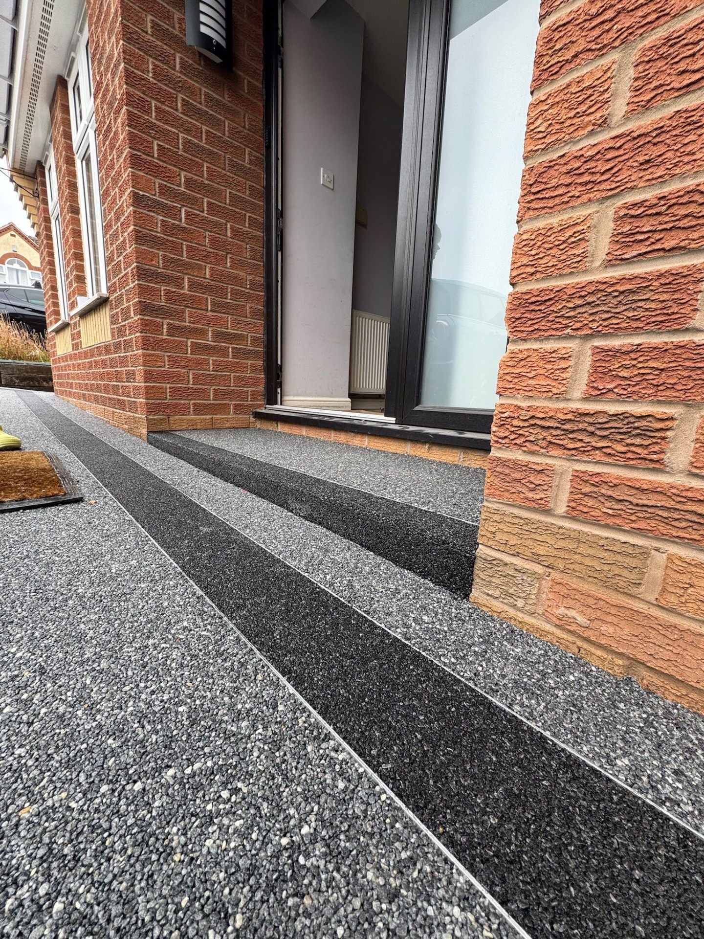 Resin bound steps with contrasting dark stripe detail at entrance